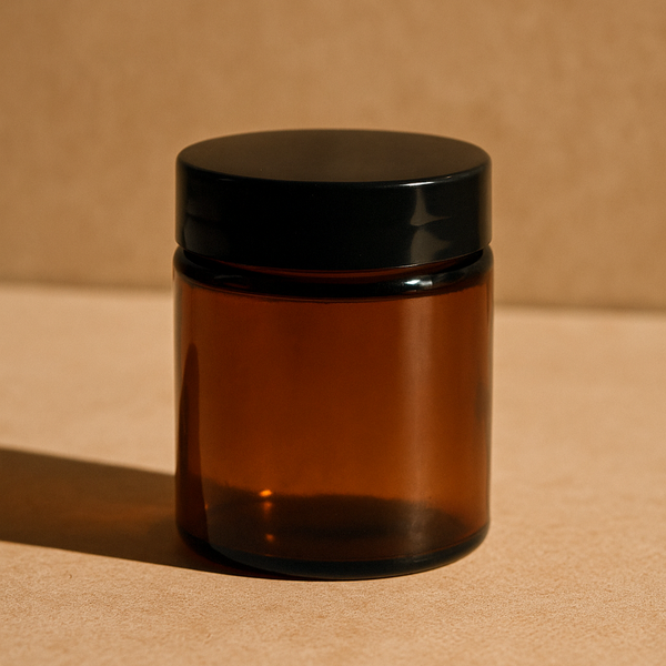 Brown glass jar with black lid on a beige background