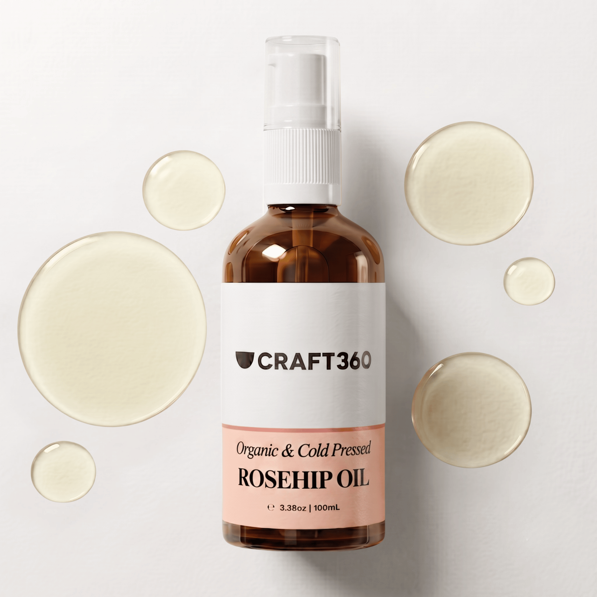 100 ml bottle of Certified Organic Rosehip Oil surrounded by pools of richly coloured oil