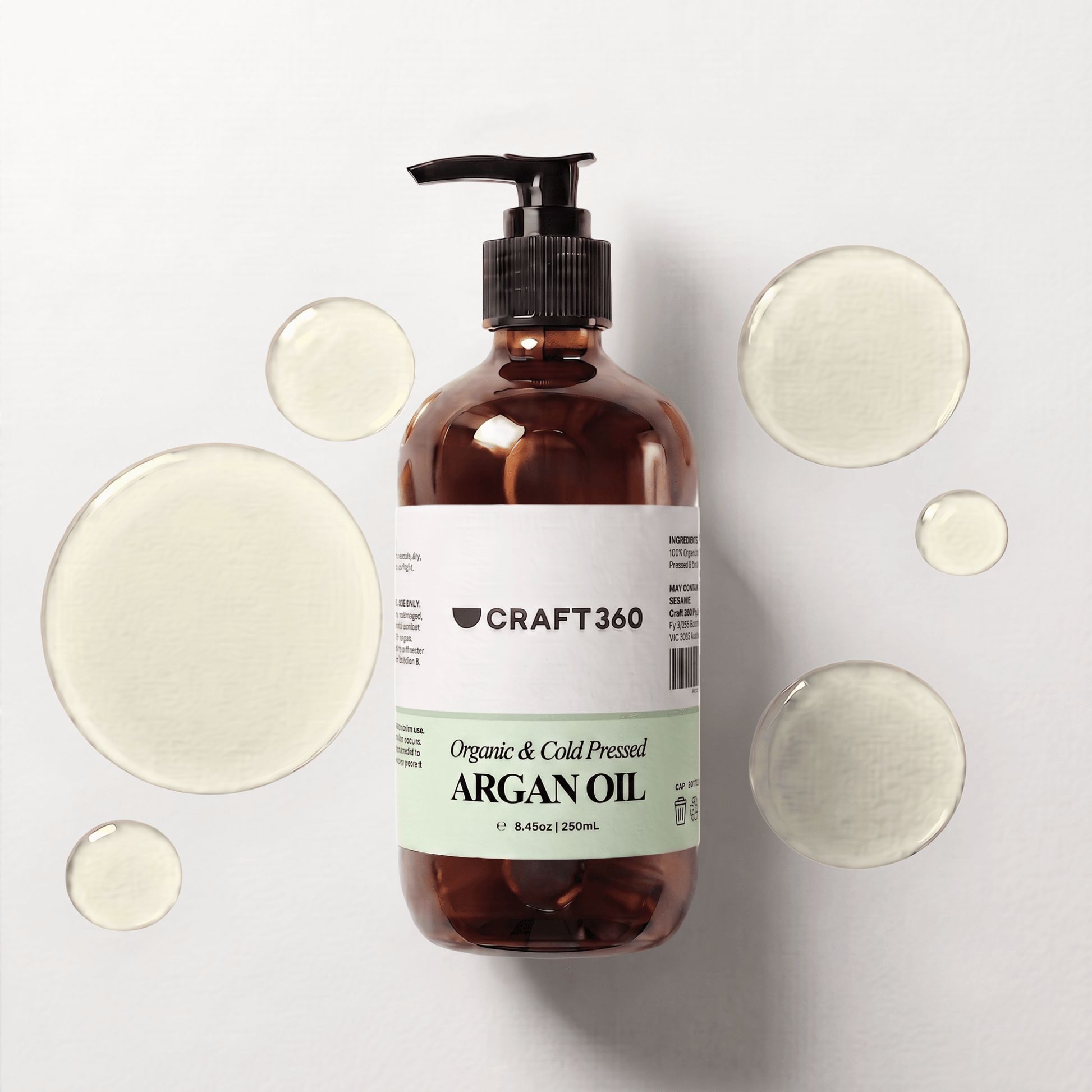 250 ml bottle of Certified Organic Argan Oil surrounded by pools of golden carrier oil