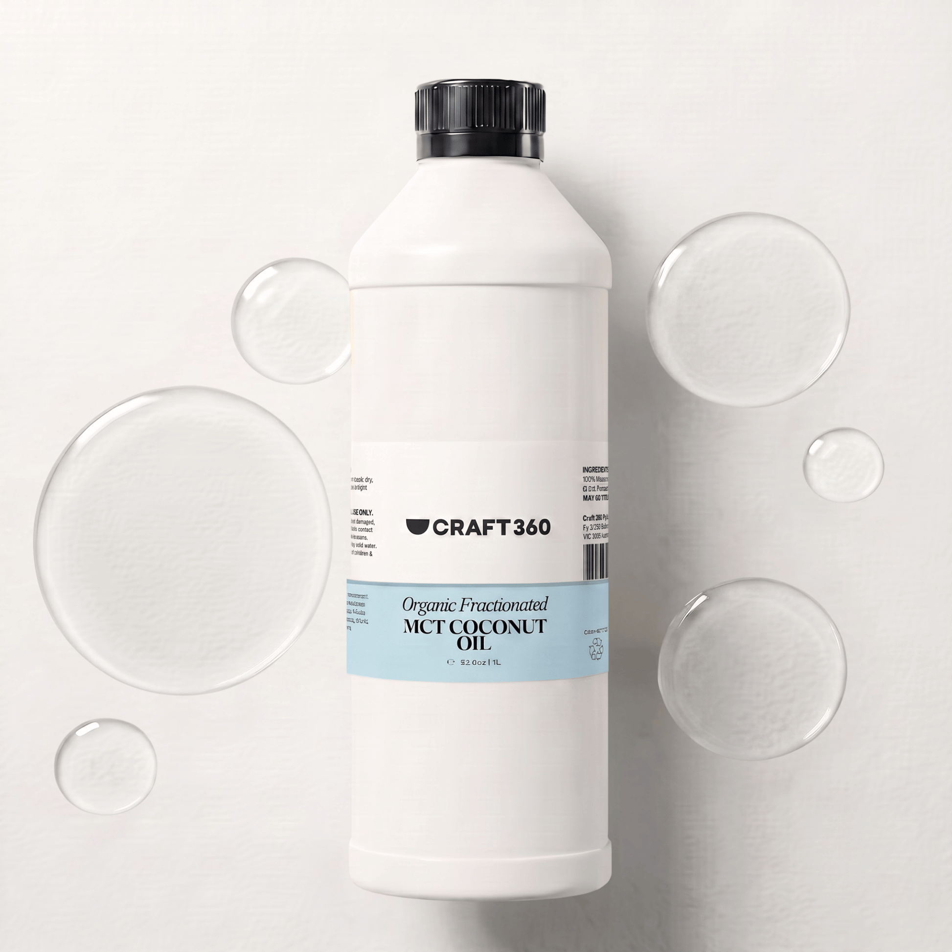 1 L bottle of Organic Fractionated Coconut Oil surrounded by pools of clear carrier oil