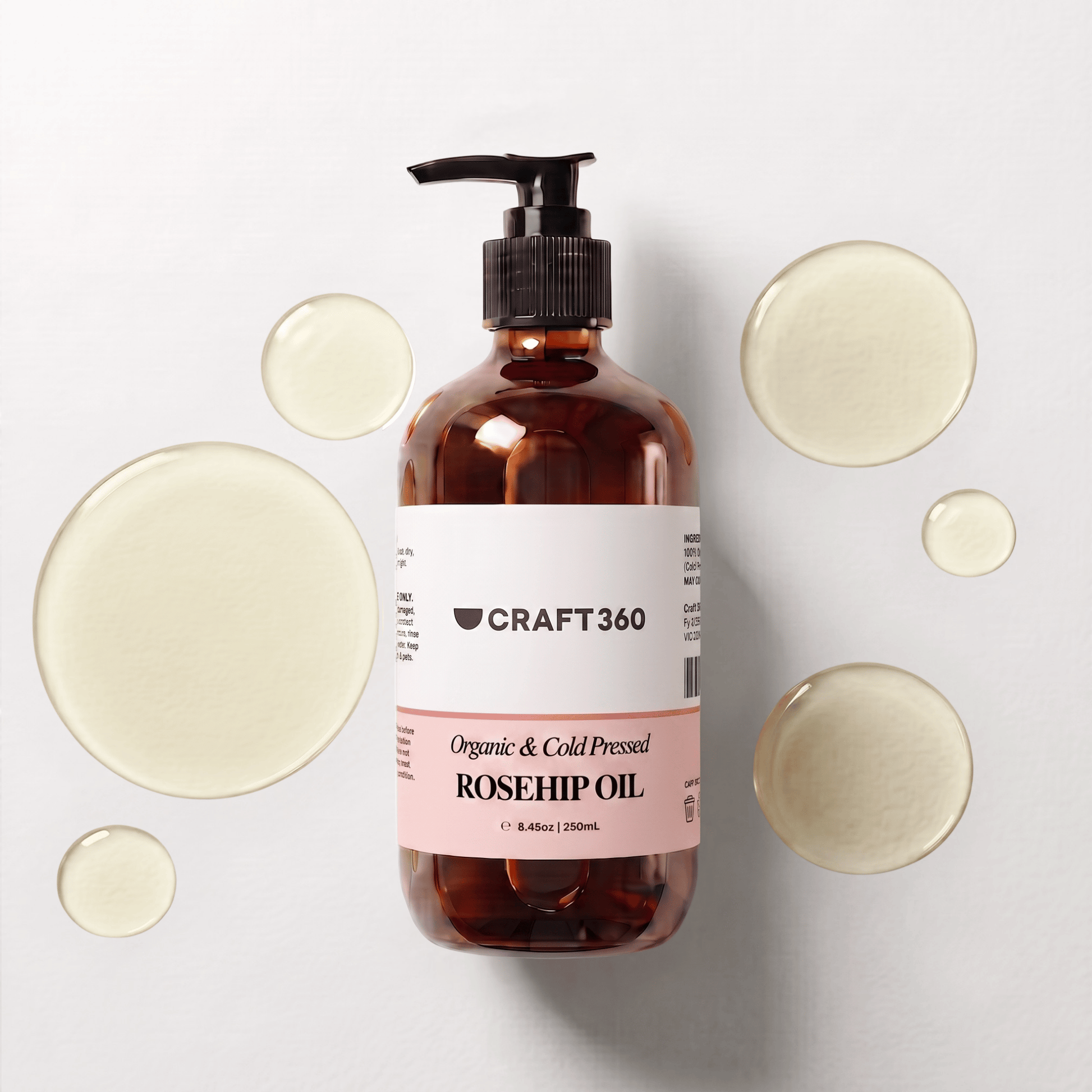 250 ml bottle of Certified Organic Rosehip Oil surrounded by pools of richly coloured oil