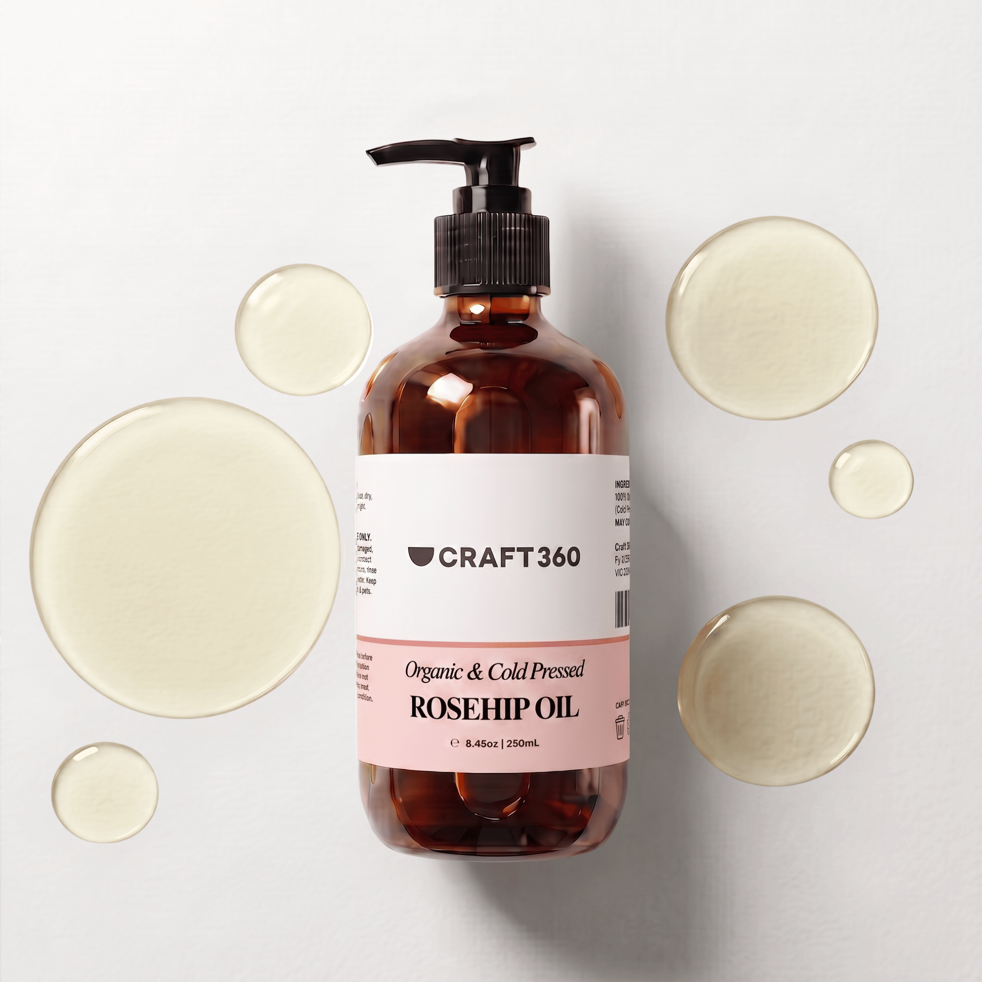 250 ml bottle of Certified Organic Rosehip Oil surrounded by pools of richly coloured oil